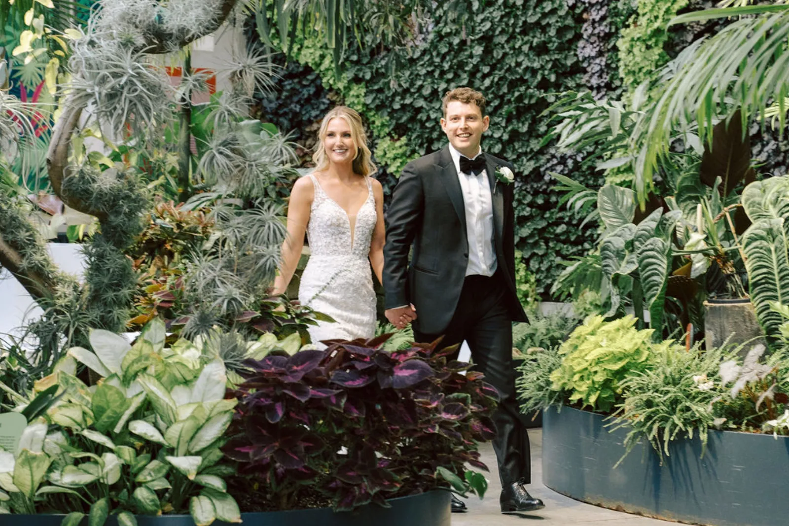Couple walking through a lush conservatory garden venue