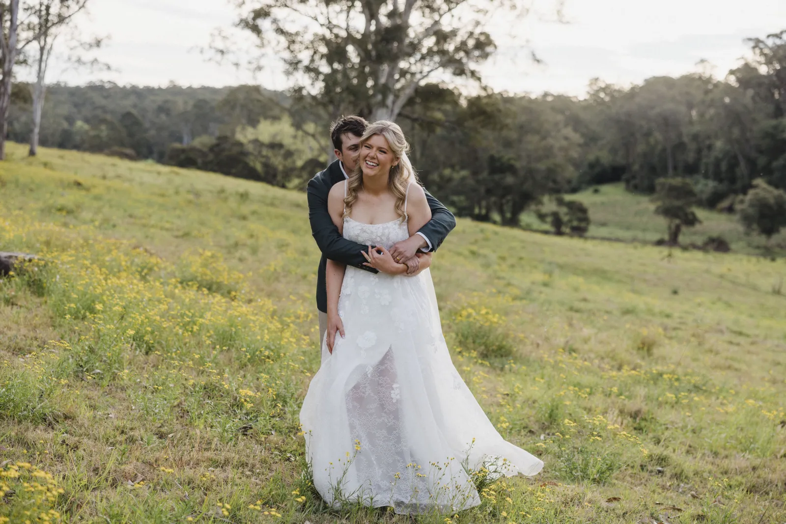 Couple embracing in an open paddock at a private-property wedding
