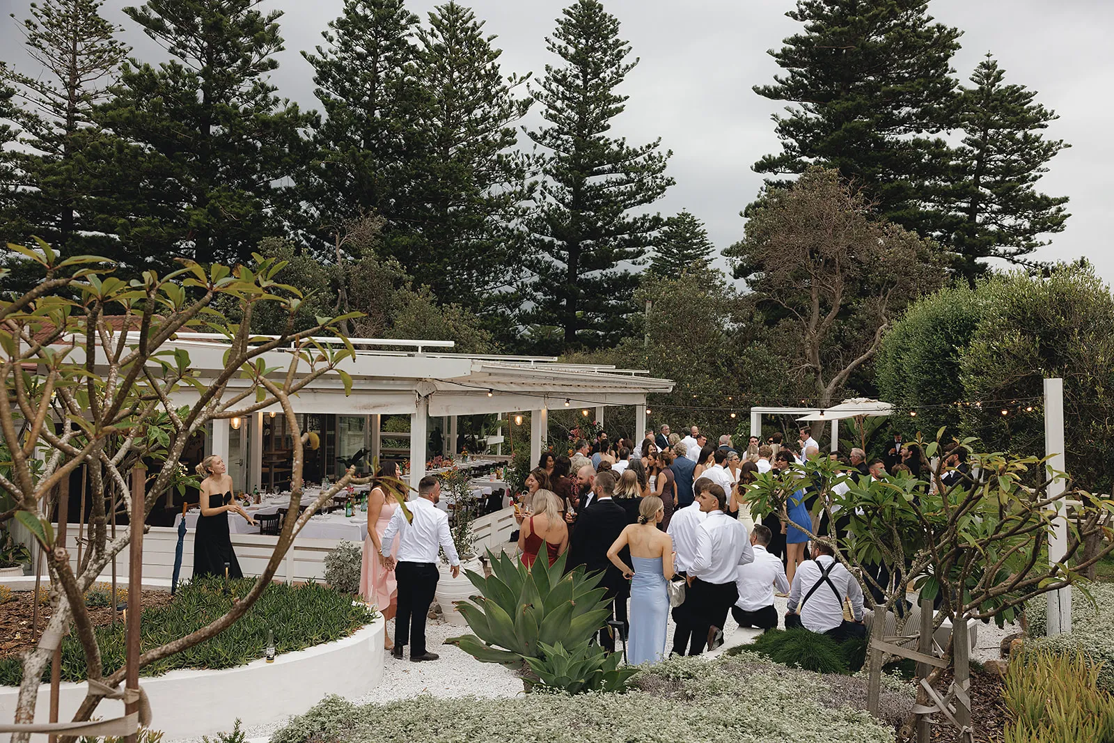 Guests gathered on the lawn after a garden wedding ceremony beside the venue