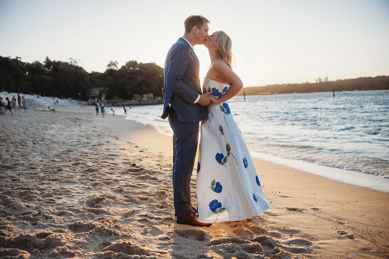 Couple sharing a kiss on a Sydney beach at sunset